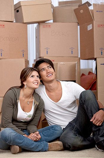 Couple portrait with boxes moving to a new home